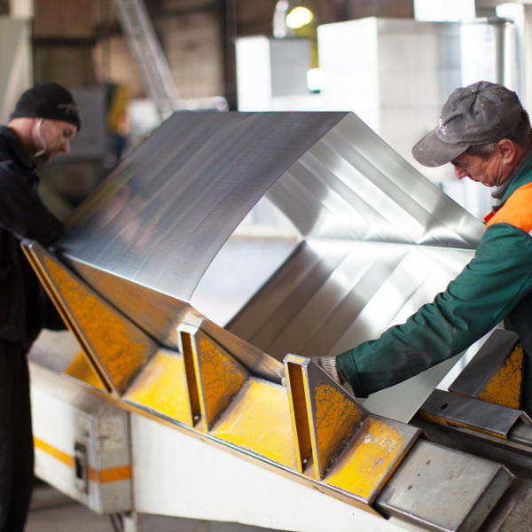 two workers make metal ventilation pipes workshop factory