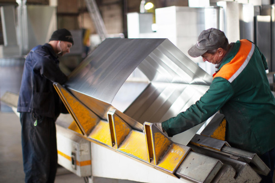 two workers make metal ventilation pipes workshop factory